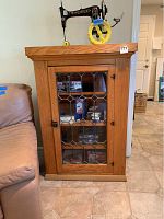 Front view of vintage oak cabinet showing leaded glass door and wooden frame.
