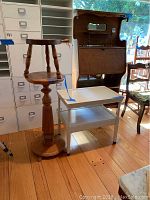 Group photo showing the wooden column table, white end table with drawer, and small wooden stool.