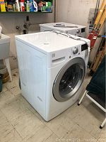 Front and left side view of Kenmore front load washer showing cabinet shape and overall condition