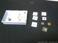 Box holding multiple Canadian coins including 1-cent and 5-cent coins, some loose and some in 2x2 holders.