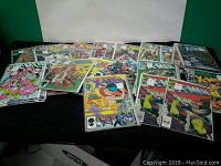 Spread of individually wrapped X-Men comic books displayed on a black surface, showing multiple issue covers.