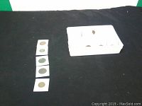 Coins displayed loosely on fabric background.