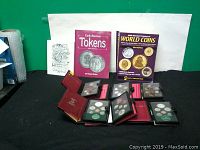 Overall view of the lot showing six Royal Canadian Mint coin sets in cases and three coin books.