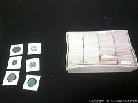 Photo of several Italian coins in protective holders laid out on black surface, showcasing varied sizes and denominations.