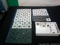 Photo shows USA coins placed in plastic sheets with coin slots and a white tray filled with individually labeled coin holders.