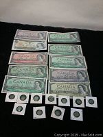 Twelve banknotes laid in rows above eleven silver five-cent coins in individual holders
