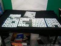 Wide shot of coin sleeves arranged on table in rows, showing quantity and method of storage