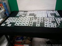 Wide view of a table covered in 2x2 coin holders displaying multiple coins in stacks and rows