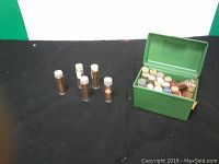 Green plastic container filled with various coin tubes and rolls.