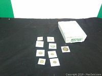 Selection of British penny coins in individual holders placed on black fabric