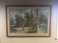 Full view of the framed oil painting showing a wooded landscape with two women walking and autumn trees under an overcast sky.