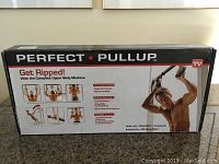 Box of Perfect Pullup workout apparatus showing product branding and exercise illustrations.
