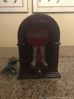 Front view of Coca-Cola radio featuring stained glass design and control knobs.