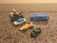 View of all six vintage metal toy vehicles on a surface.