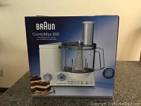 Front of box showing Braun CombiMax 600 food processor image and product details including 600 Watt power