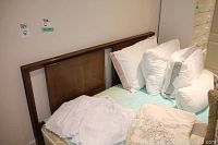 Photo of queen size bed showing wooden headboard's front and bedding.