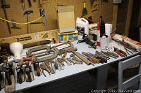 Workbench surface with hand planes, C-clamps, vise, hammers, assorted hand tools