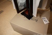 Photo of the Bombay brand photo frame flip stand on box, showing dark wood finish and base details.