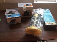 Three boxed corded phones and two boxed/packaged pumps on a table