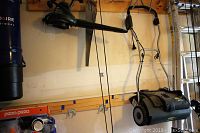 Photo shows electric YardWorks dethatcher hanging on the wall along with a hand saw and leaf blower also mounted on the wall.