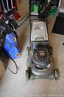 Front view of Craftsman mulching lawn mower with Dust Blocker bag and visible wear on wheels and deck