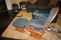 Side view of chair and ottoman on carpet showing wooden frame and cushioned upholstery.