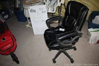 Black Serta massage office chair positioned on basement floor showing the overall condition and items including plug and remote.