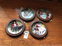 Four framed decorative plates laid out on a wooden floor, clearly showing the size, overall design, frame style, and multiple scenes from The King and I series.