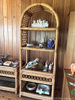 Front view of tall rattan shelf with decorative lattice sides and glass shelves showing items placed for display