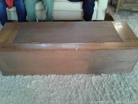 Top view of rectangular wooden box with hinged lid closed, showing dark brown wood finish and some surface wear.