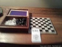 Chess set with carved wooden box and foldable board on wooden surface