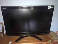 Front view of Toshiba Regza 42-inch flatscreen TV on wooden surface with visible stand and range sticker.