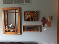 Four pieces of wall art mounted on wall including pine window mirror and two 3D wood art pieces