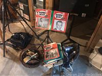 Photo showing Wenger music stand holding two Down Beat magazines, audio equipment on floor including microphone and cables.