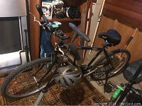Side view of Raleigh Big Horn men's bike with helmet hanging on frame, showing tires and front light on handlebar.