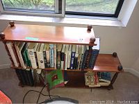 Wooden bookcase filled with various books, shown from front and angled side view