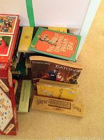 Lot items displayed on a flat surface including Eaton's Catalogue, wooden cribbage board, and assorted vintage books.