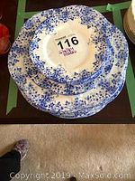 Top view of stacked plates showing the blue floral spatter pattern and scalloped rims