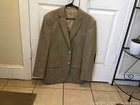 Front view of beige Eddie Domani blazer with subtle checked pattern, showing front pockets and two white buttons.