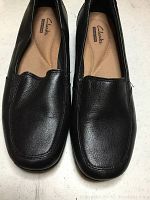 Top view showing the black leather upper, squared toe design, and branded cushioned insole