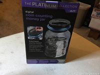 Box of the Platinum Collection digital coin counting money jar showing product and brand name with image of the item