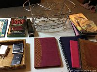 Overview of the lot showing books, desk organizer, journals, stapler, batteries, and tray