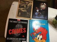 Four books laid out, including Life magazine special edition on crimes, Woody Woodpecker book, birth control handbook, and TQS cartoon book