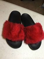 Top-down view of both red fuzzy slippers showing full pair and texture.