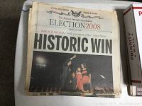 Front page of The Atlanta Journal-Constitution newspaper headline 'HISTORIC WIN' featuring Barack Obama with his family on stage.