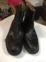 Front view of the pair of black leather boots, showing rounded toe and creasing on the surface.