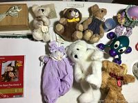 Mini teddy bears, white rabbit plush, and spider-shaped handheld massager on table