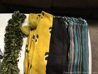 Four scarves displayed side by side showing different colors and materials.