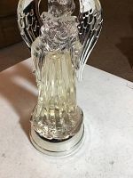 Front perspective showing clear angel figure with silver wings and base.