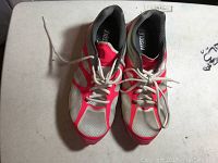 Top-down view of the Nike Fitsole sneakers showing white mesh and red overlays with white laces on a flat white surface.